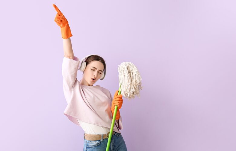 Young,Woman,With,Floor,Mop,Listening,To,Music,On,Color